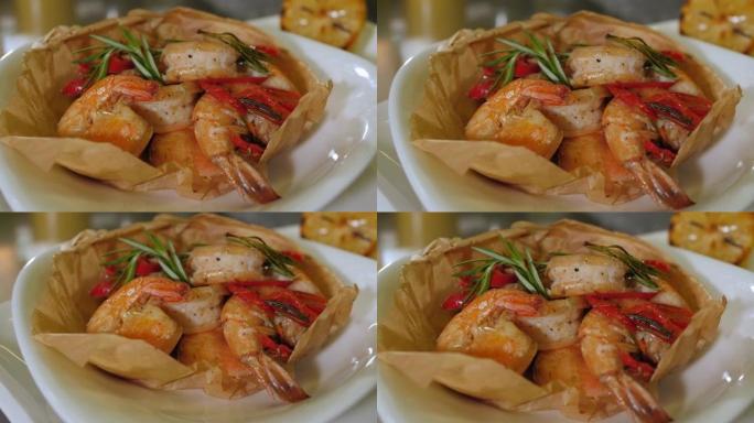 在一家餐馆的盘子上放有虾和迷迭香的菜的特写镜头。
