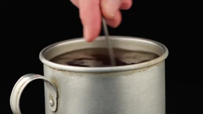 搅拌一个装有茶匙的旧锡杯