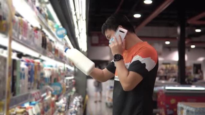 亚洲男子在超市购物时戴着防护口罩。