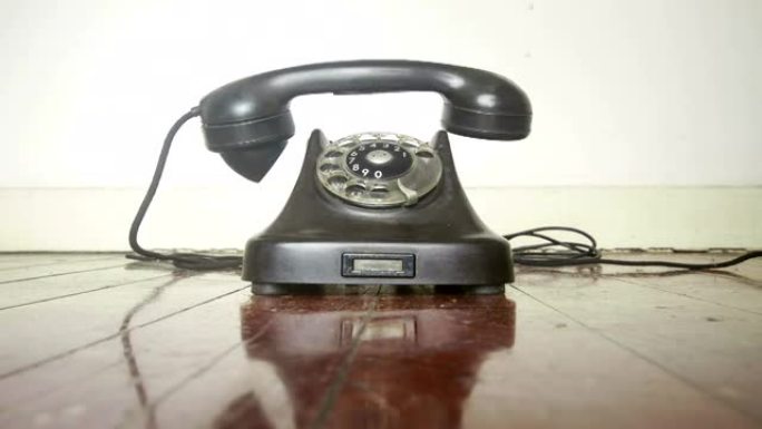 老式黑色电话在旧木地板上响起