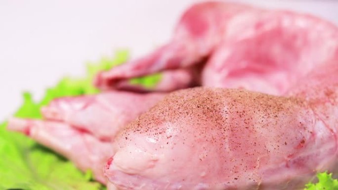 厨师在兔肉上撒上黑胡椒。肉类调味料，烹饪低脂肉类