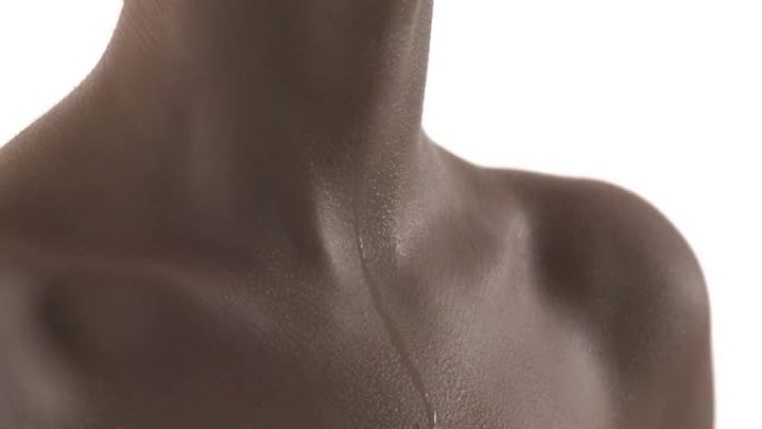 汗珠滴在一个无法辨认的白人女人的胸膛上。靠近颈部和锁骨区域的湿皮肤。沉重的呼吸。在白色背景上隔离