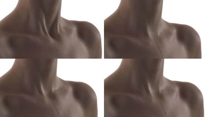 汗珠滴在一个无法辨认的白人女人的胸膛上。靠近颈部和锁骨区域的湿皮肤。沉重的呼吸。在白色背景上隔离