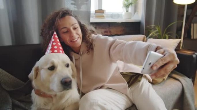 欢乐的女人在派对帽子里和狗自拍