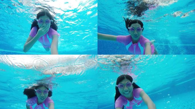 快乐的亚洲女孩和家人一起在游泳池游泳，在水下射击。
