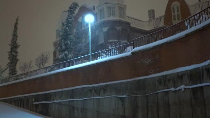 夜间4k暴风雪在路灯照亮的街道上。菲洛梅娜风暴带来的大雪。西班牙马德里特雷斯坎托斯。
