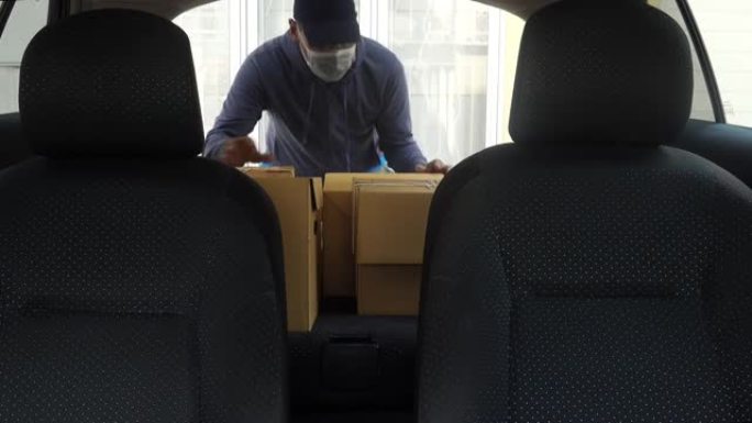 成熟的小企业主戴着口罩送货包裹给顾客开车