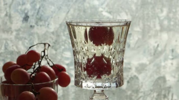 葡萄漂浮在一杯香槟中，窗户上有冰花