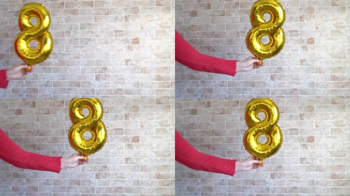 女性手中的金箔气球数字8。妇女节快乐，复制空间