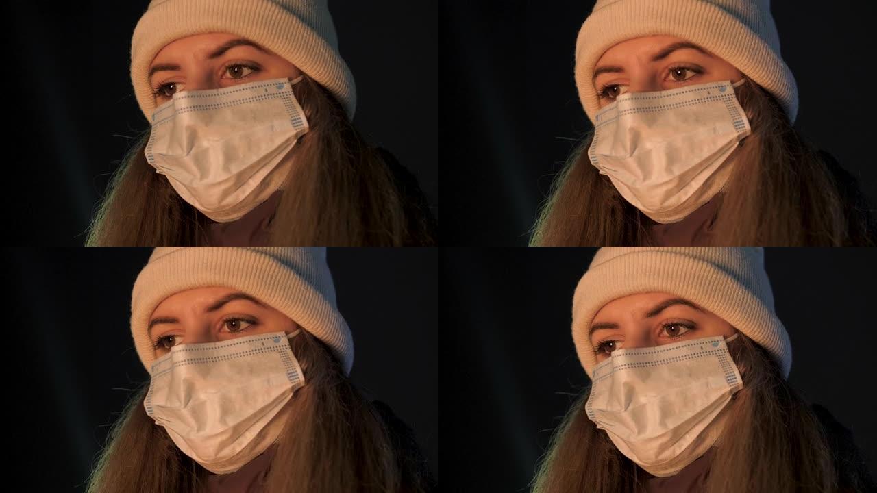 脸上戴着抗病毒面具的女人希望在冬夜看着火