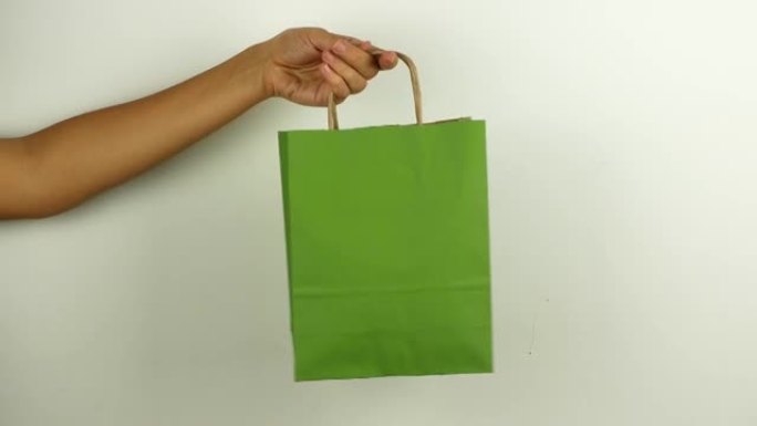 一名妇女拿着一个绿色购物袋，以纪念黑色星期五和网络星期一。折扣当天购买的套餐的4k视频特写镜头。