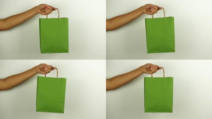 一名妇女拿着一个绿色购物袋，以纪念黑色星期五和网络星期一。折扣当天购买的套餐的4k视频特写镜头。