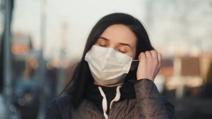 病毒口罩西班牙女子在街头戴口罩摘下口罩结束冠状病毒19的隔离。大流行疫情结束