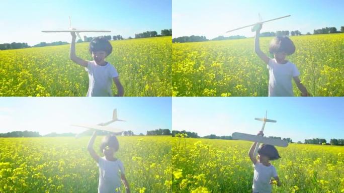 快乐的小男孩在黄花田里用玩具飞机奔跑。孩子在户外夏天玩飞机。小飞行员梦想着飞行，和幸福的家人一起度假