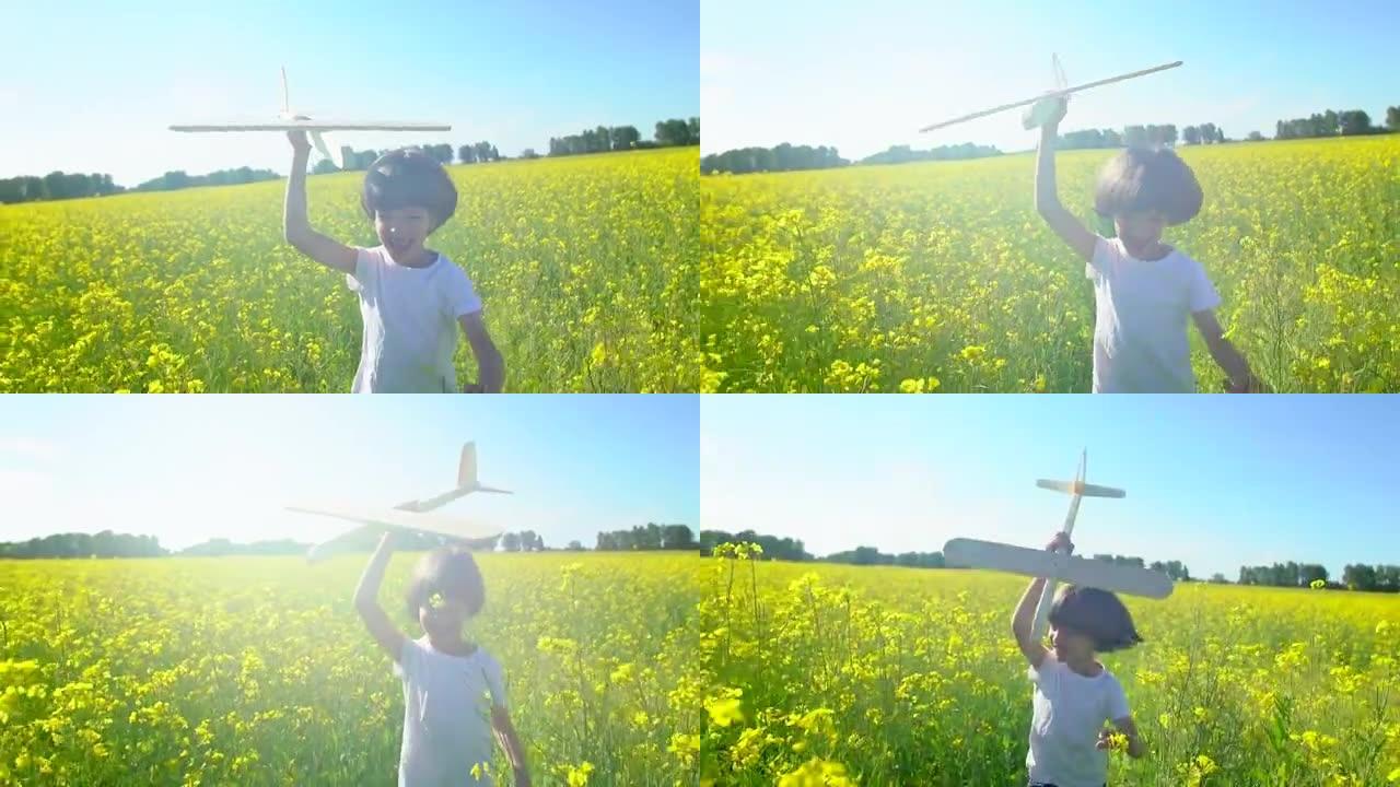快乐的小男孩在黄花田里用玩具飞机奔跑。孩子在户外夏天玩飞机。小飞行员梦想着飞行，和幸福的家人一起度假