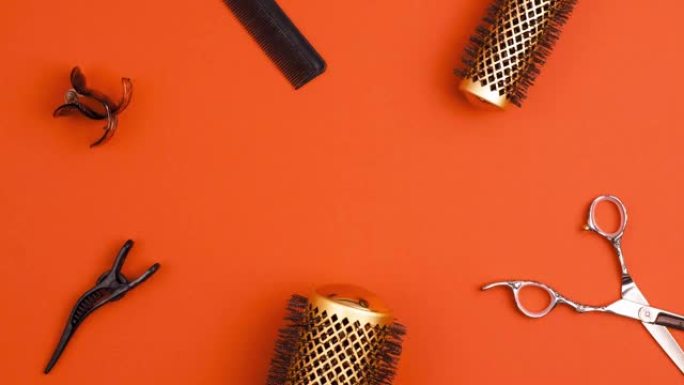 专业剪发剪梳子的定格动画，用于分离发夹部分发夹和金色圆形发刷，用于橙色造型。美发师沙龙设备