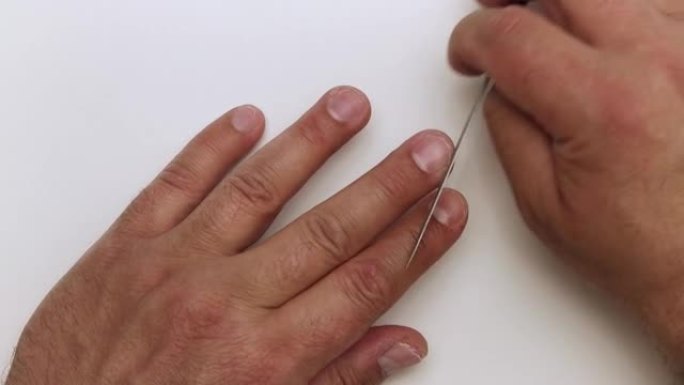 指甲锉的特写处理男人的手的中指。