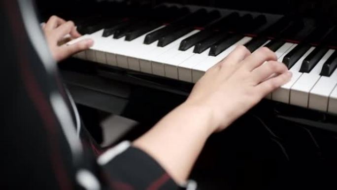 女性年轻的手弹奏钢琴的手在大钢琴上弹奏柔和的古典音乐。专业钢琴家在线钢琴课。