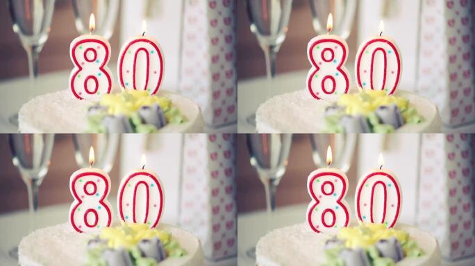 生日蜡烛作为80号80在桌上的甜蛋糕上，80岁生日，调色视频高清