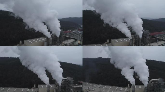 工业厂房的鸟瞰图，同时排放的烟雾从烟囱流入大气