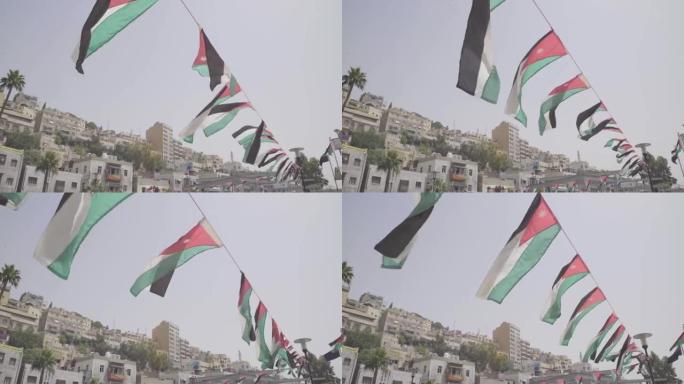 许多约旦国旗在微风中飘扬在约旦安曼街道上的一根绳子上