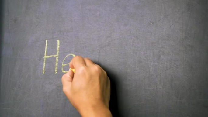 一个女人拿着粉笔在黑板上写着 “你好” 的特写。