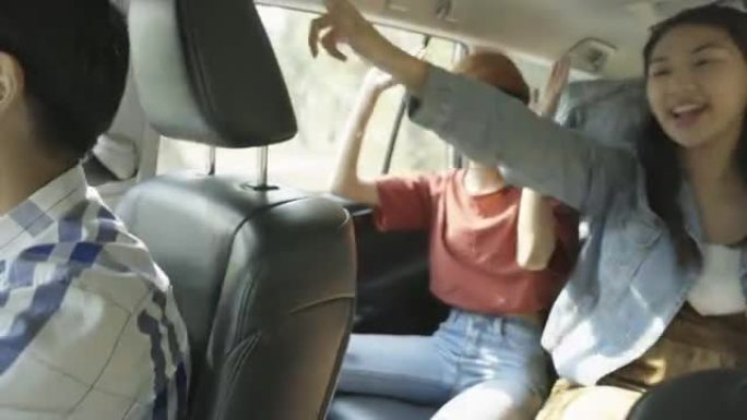 亚洲女性朋友听音乐摇摆身体，享受车内