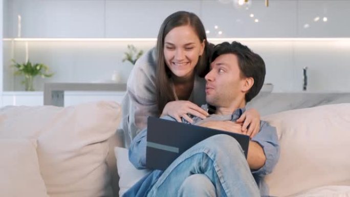 开朗的夫妇看着笔记本电脑的屏幕