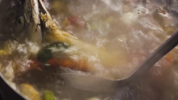 沸腾的汤被搅了起来。充满了鱼肉、红辣椒、青柠叶、大葱、高良姜和柠檬草。草药汤的配料。泰国菜菜单。