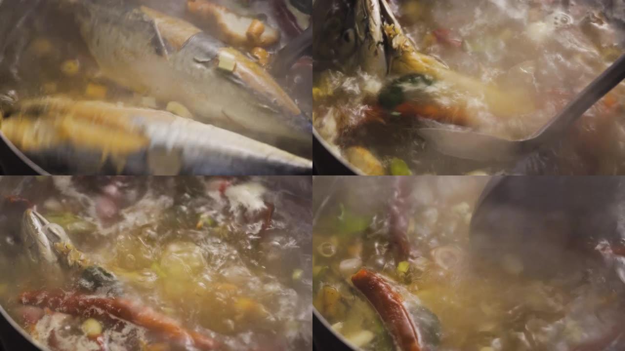 沸腾的汤被搅了起来。充满了鱼肉、红辣椒、青柠叶、大葱、高良姜和柠檬草。草药汤的配料。泰国菜菜单。