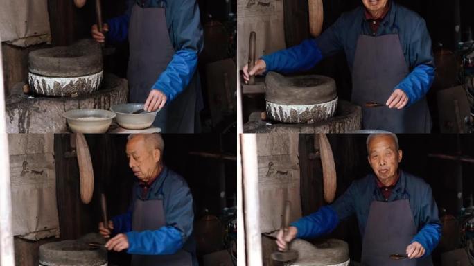中国老木棚里的高级男子碾磨谷物