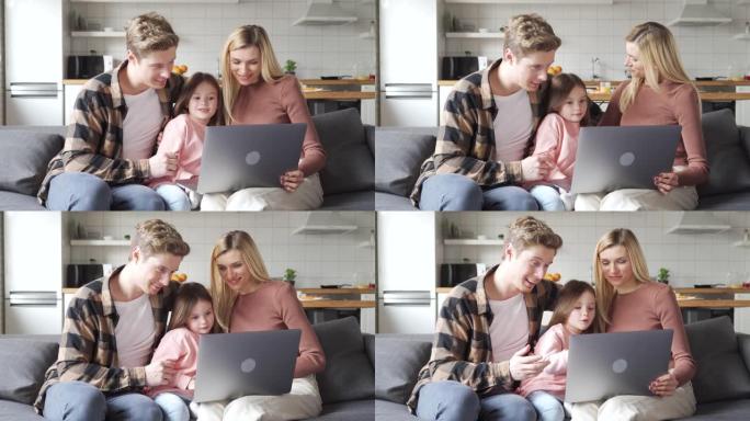 快乐的父母与小女儿交谈，在家使用笔记本电脑进行视频通话。