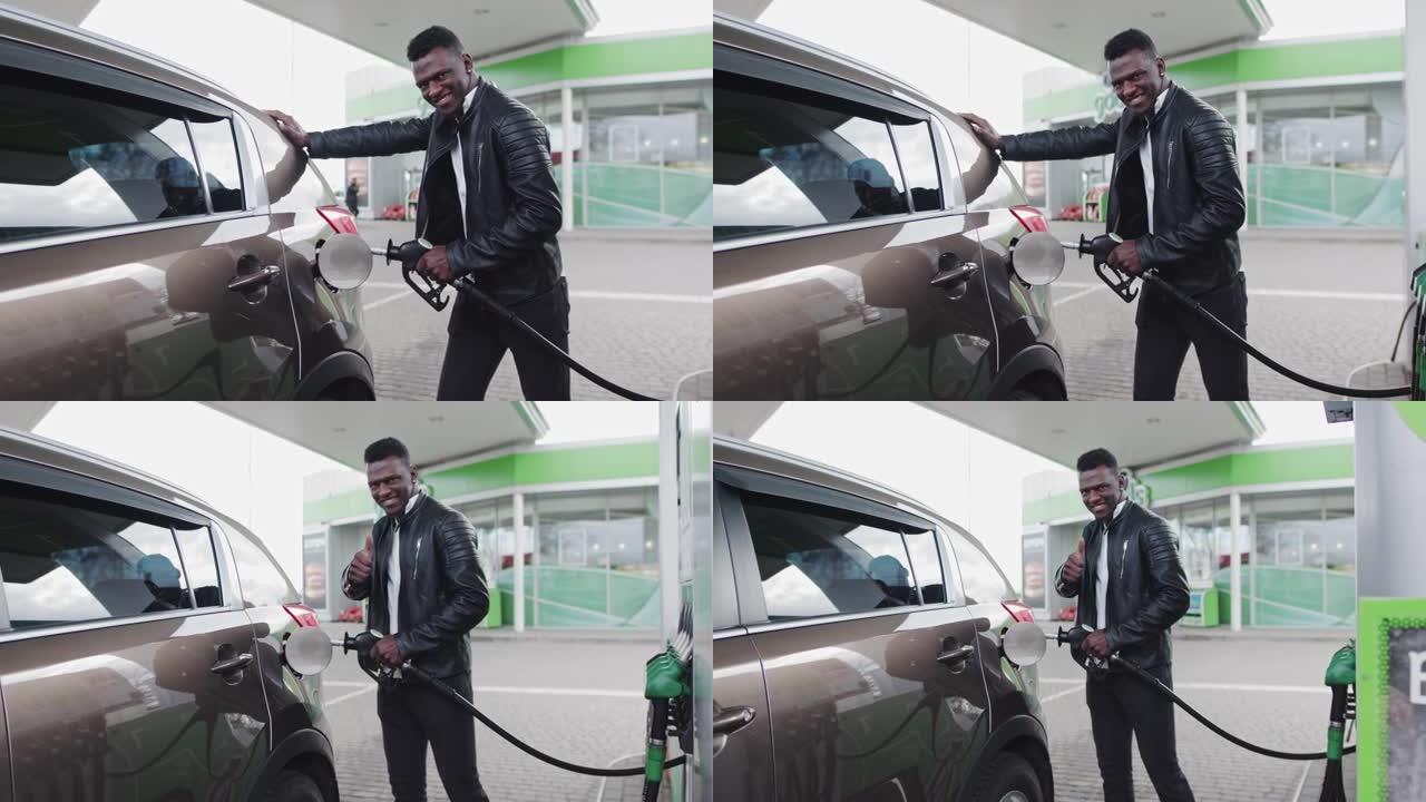 非裔美国时尚男子在他吉普车附近的加油站。该名男子为他的汽车加油，看着相机微笑。燃料，加油站，汽油价格