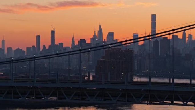 日落时分，在RFK大桥和阿斯托里亚的经济适用房项目上，曼哈顿天际线轮廓的远处景色。带有平移摄像机运动