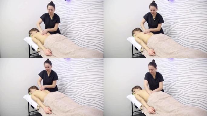 肩胛骨区域患者背部按摩，女按摩师