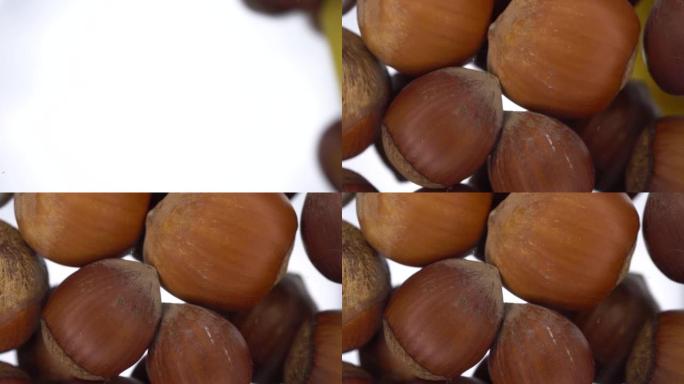 贝壳中的榛子落在明亮的白色背景上的玻璃上。榛子的特写底图。