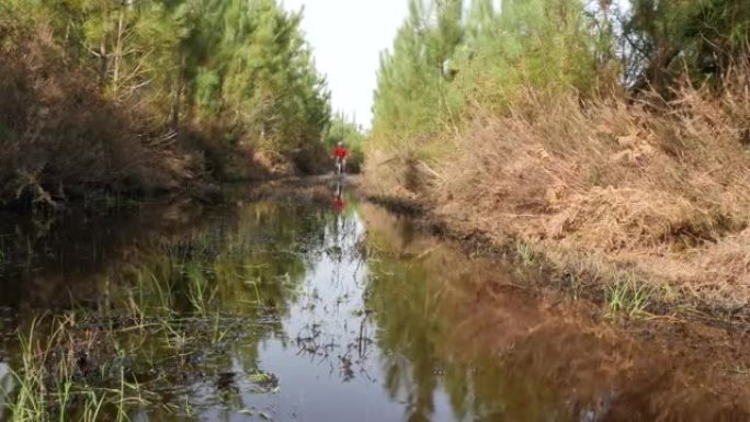 男子山地自行车在洪水泛滥的道路上行驶