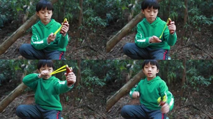 弹弓射击的小男孩小男孩野外树林打弹嗯