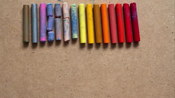 许多彩色油彩蜡笔的背景，俯视图。停止运动。