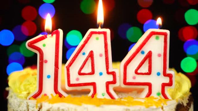 144号生日快乐蛋糕与燃烧的蜡烛顶。