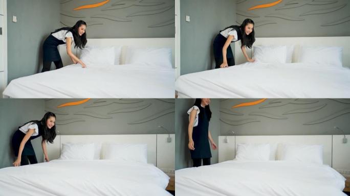 年轻的女仆，戴着医用口罩，在酒店房间的床上换床单。