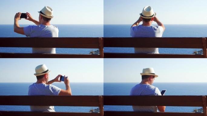 年轻人在悬崖边的长凳上放松，用手机拍照。男人享受迷人的海景