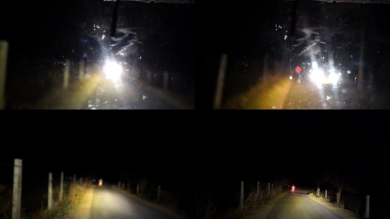 夜间汽车通过道路。汽车在夜路和过往自行车眩光的背景下行驶。特写。4K