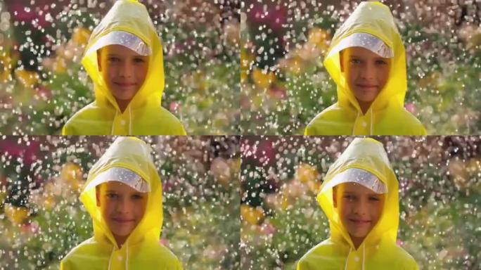 小快乐可爱的男孩孩子穿着黄色雨衣，享受着快乐的降雨。孩子看着相机，玩弄雨水的阳光。快乐家庭夏天秋天秋