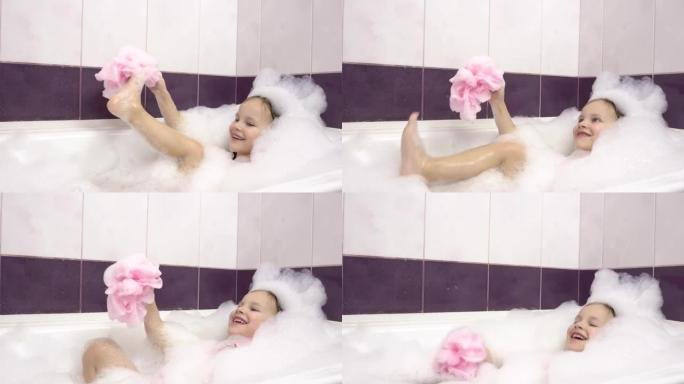 一个小女孩在泡泡浴中用一块粉红色的浴巾擦腿上的泡沫。很多foam.4k