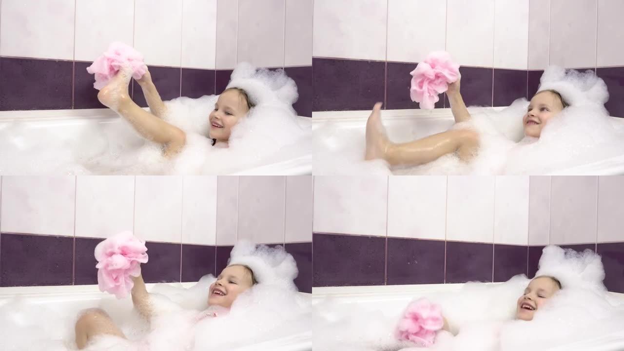 一个小女孩在泡泡浴中用一块粉红色的浴巾擦腿上的泡沫。很多foam.4k