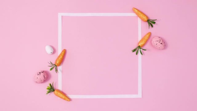复活节彩蛋和胡萝卜出现在明亮的粉红色背景上的复制空间框架周围。停止运动平铺