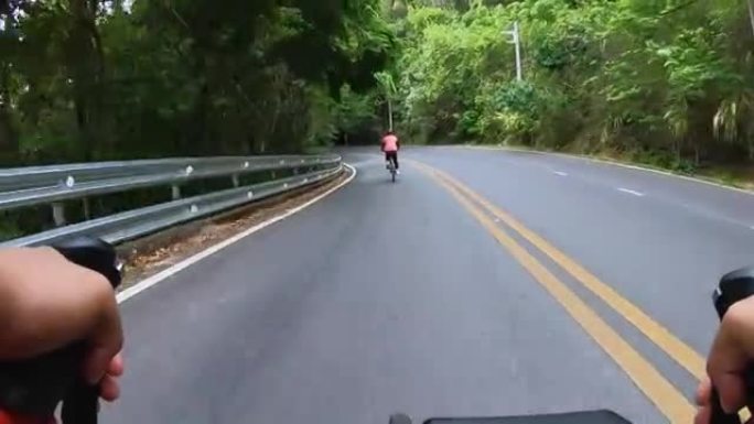 从角度来看，一名骑车人与一名女骑车人一起沿着山路行驶。