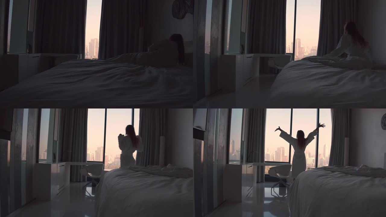 女人在酒店房间里放松，走到窗前享受日出的光芒。慢动作