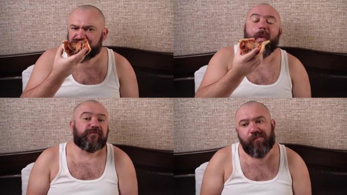 一个大胡子的男人坐在家里的床上，通过网络摄像头进行视频通话，然后吃披萨。用满嘴交流